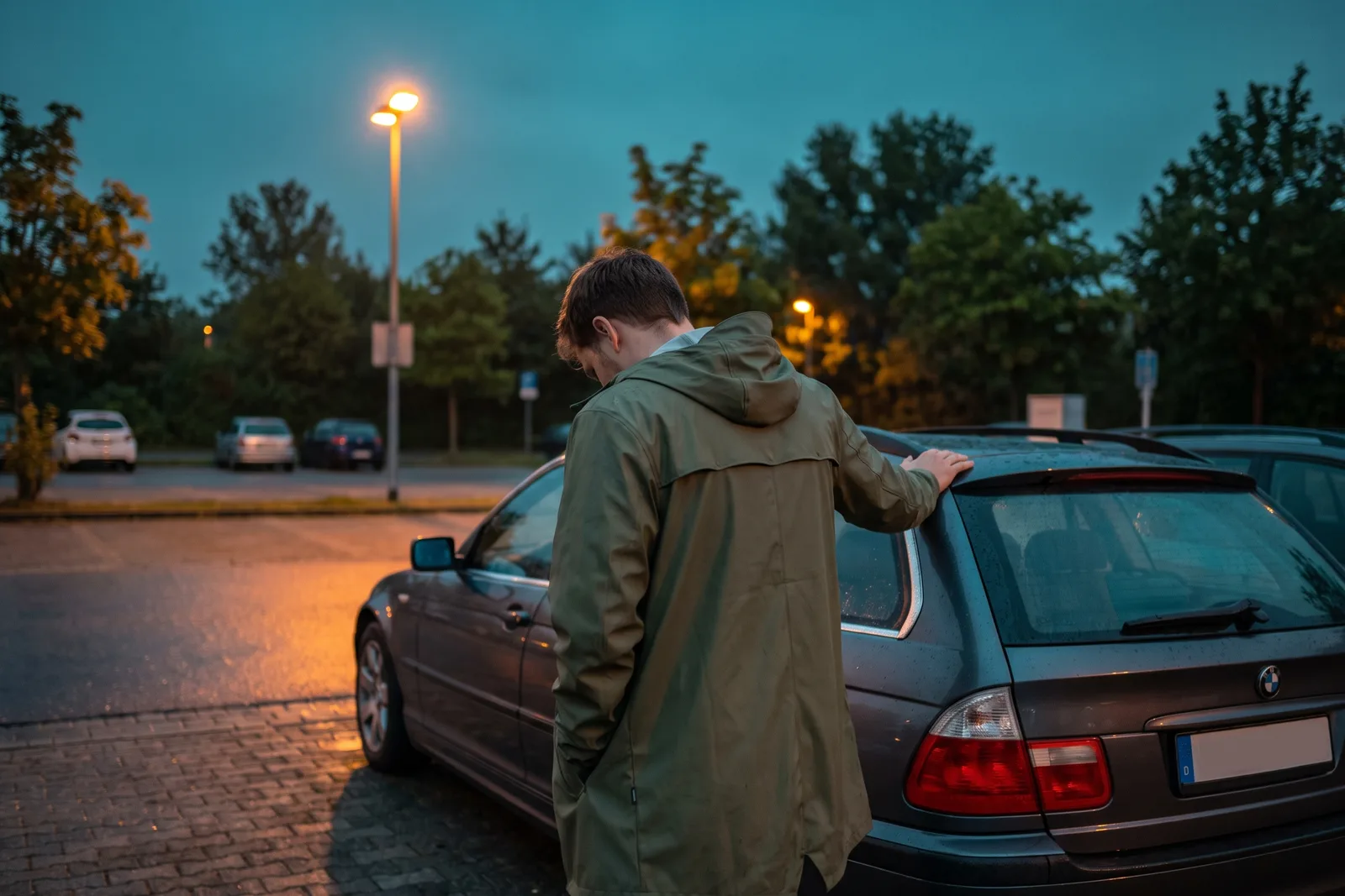 Autoschlüssel verloren: Person steht abends ohne Schlüssel am abgeschlossenen Auto