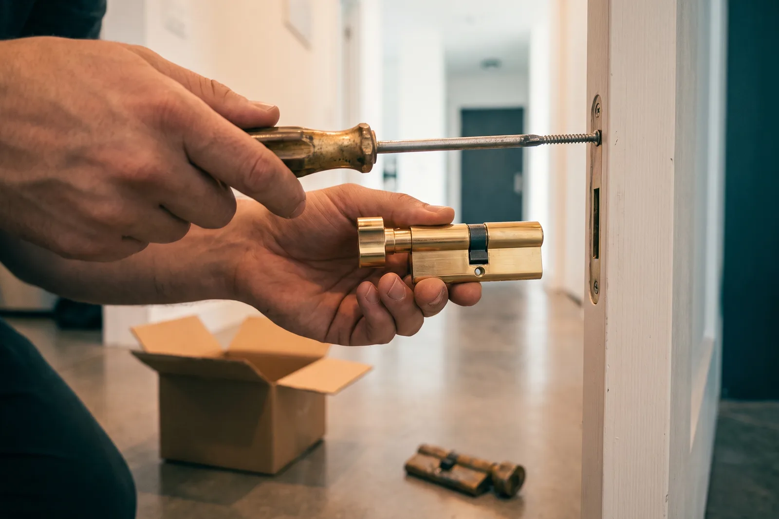 Türschloss wechseln: neuer Knaufzylinder wird in die Wohnungstür eingesetzt, Stulpschraube wird angezogen